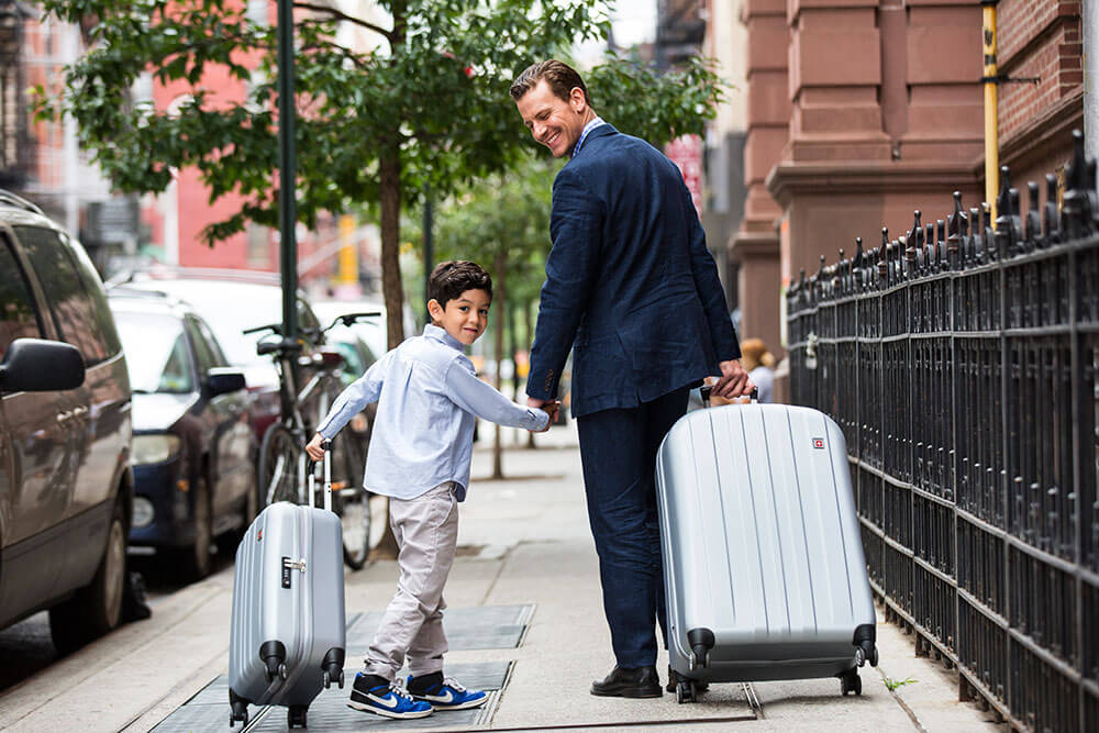 Father and son walking with SWISSGEAR luggage